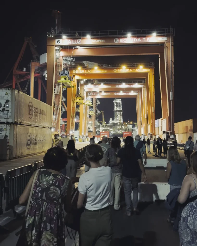 Spettatori che camminano sotto le gru del terminal container del porto di Las Palmas