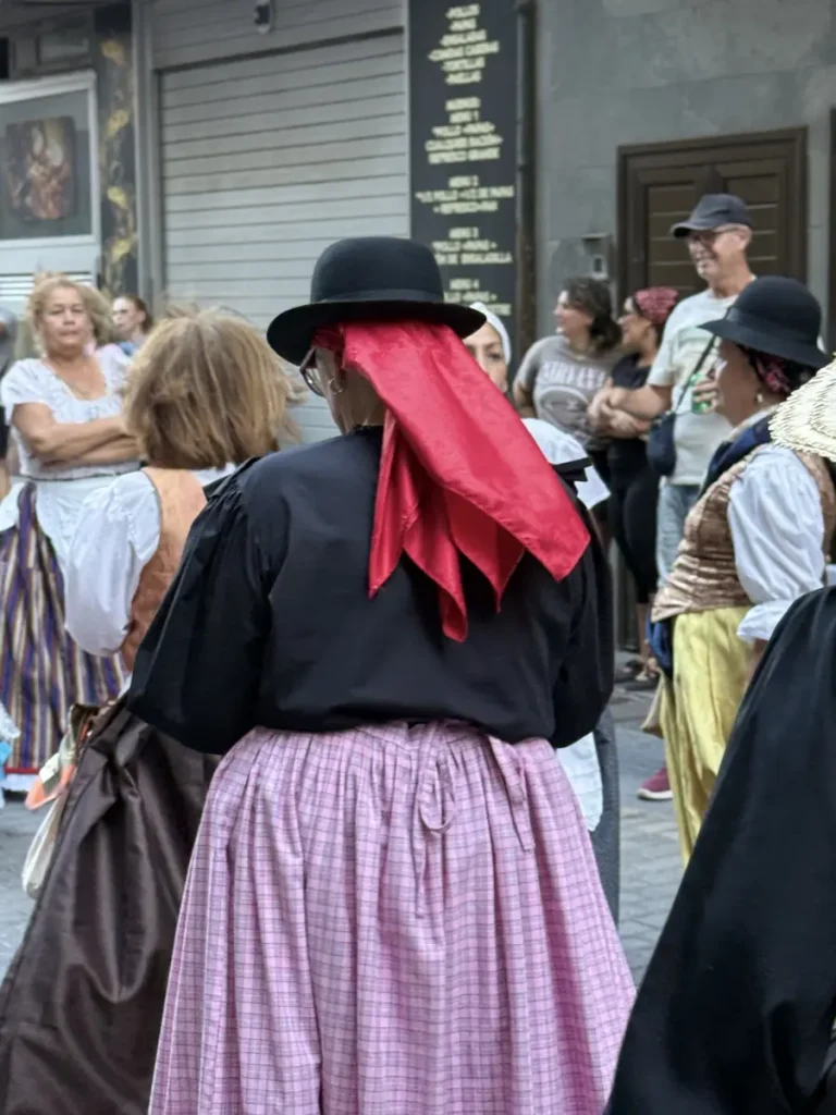 Donna di spalle con cappello nero e fazzoletto rosso nel corteo della romería di Las Palmas